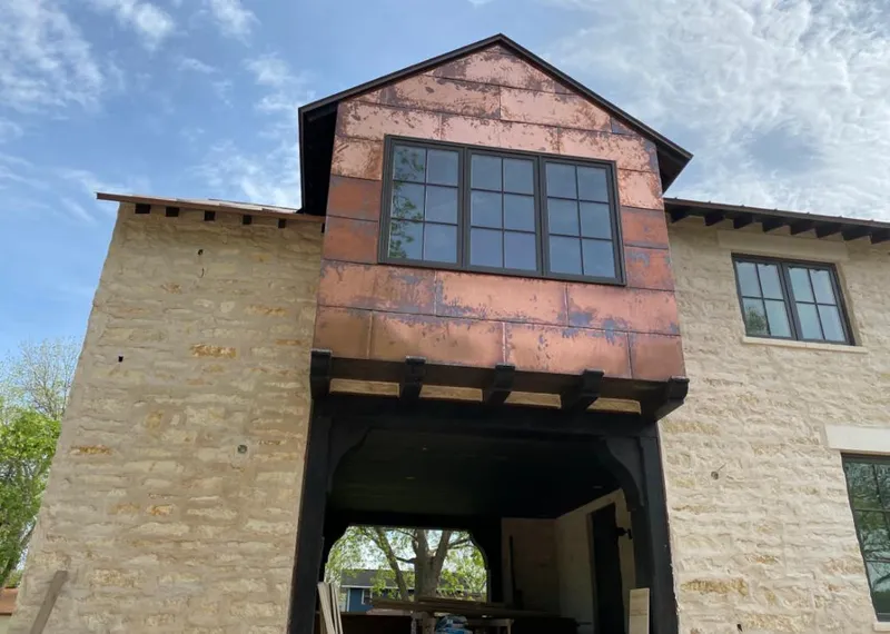 Copper metal panel facade on a stone building for Metal Roof Coating in Milliken